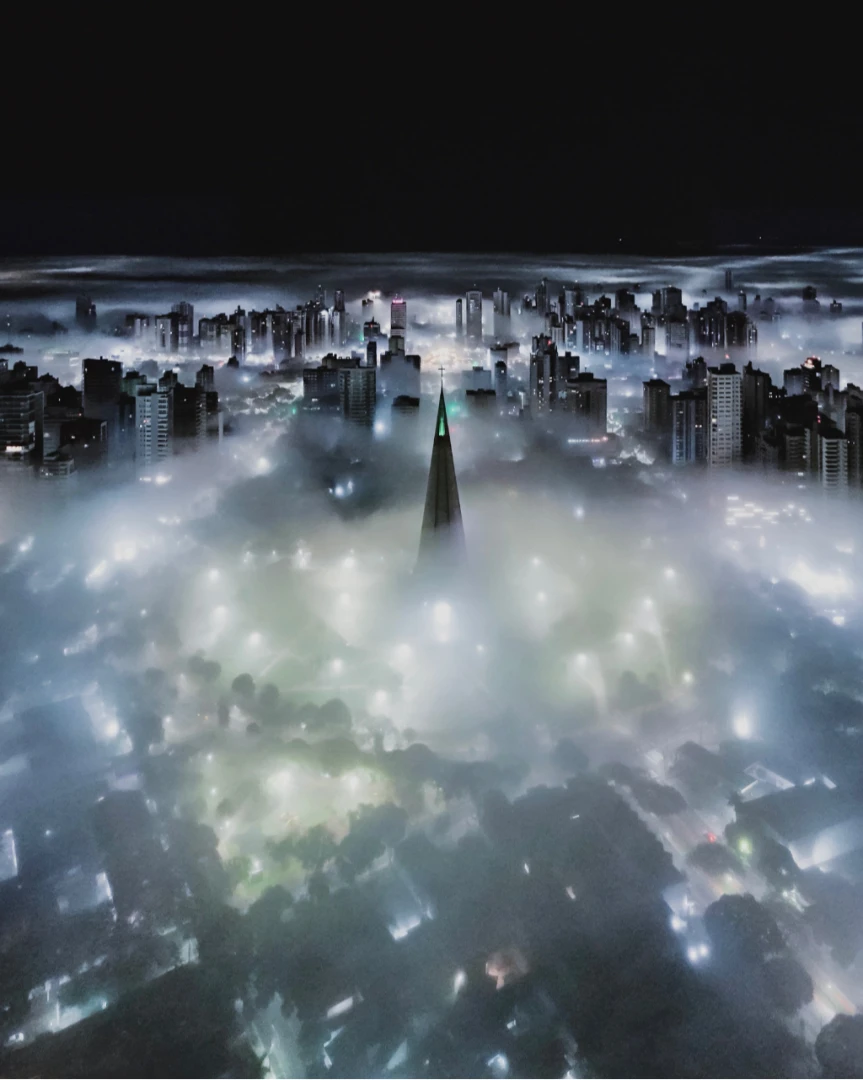 Há noites em que Maringá parece esconder uma cidade inteira sob um mar de nuvens, deixando a Catedral como guia. 22/10/2026